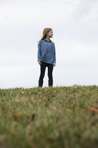 a girl standing alone outdoors 