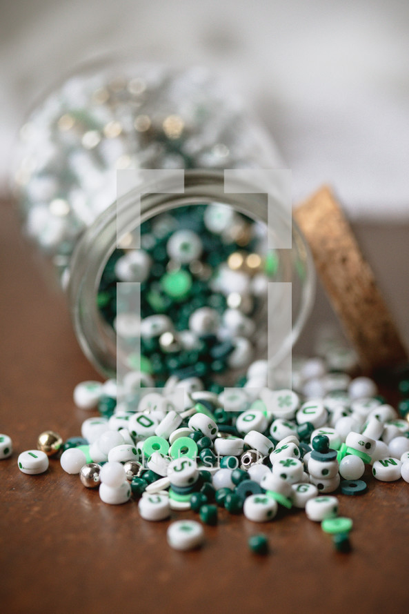 Jar of green, white, and gold beads