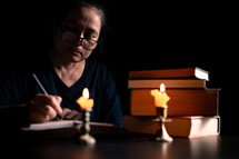 Bible and candlelight with studying woman