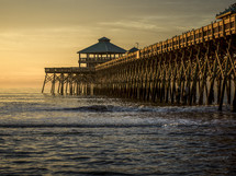 waves at a pier at sunset 