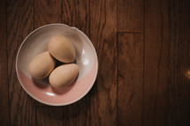 plain wooden eggs in a bowl 