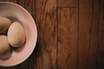 plain wooden eggs in a bowl 