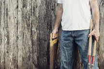 man holding saw and clippers 