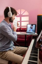 Boy teaching piano lessons with remote computer video call