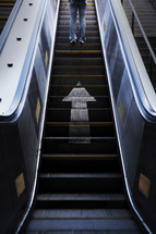 man going up an escalator 