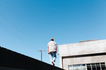 a man walking across the ledge of a building 