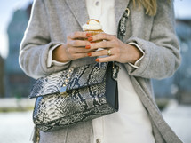a woman standing outdoors holding a cupcake 