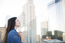 praying woman standing on a rooftop balcony