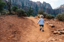 toddler boy exploring a desert path 