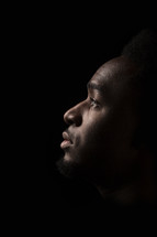 face of an African American man standing in darkness