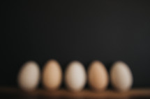 defocused speckled eggs against a black background 