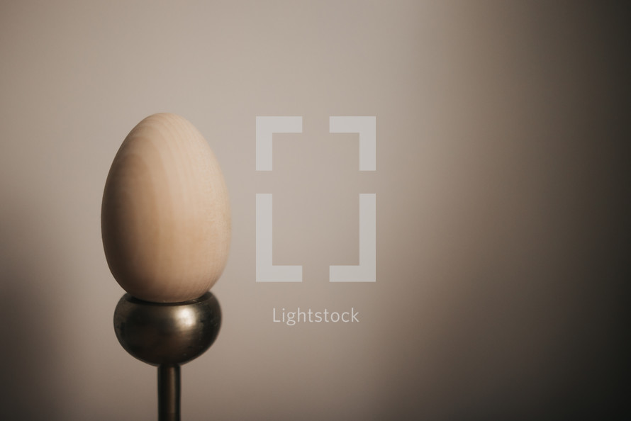 wooden eggs on candlesticks against a white background with copy space 