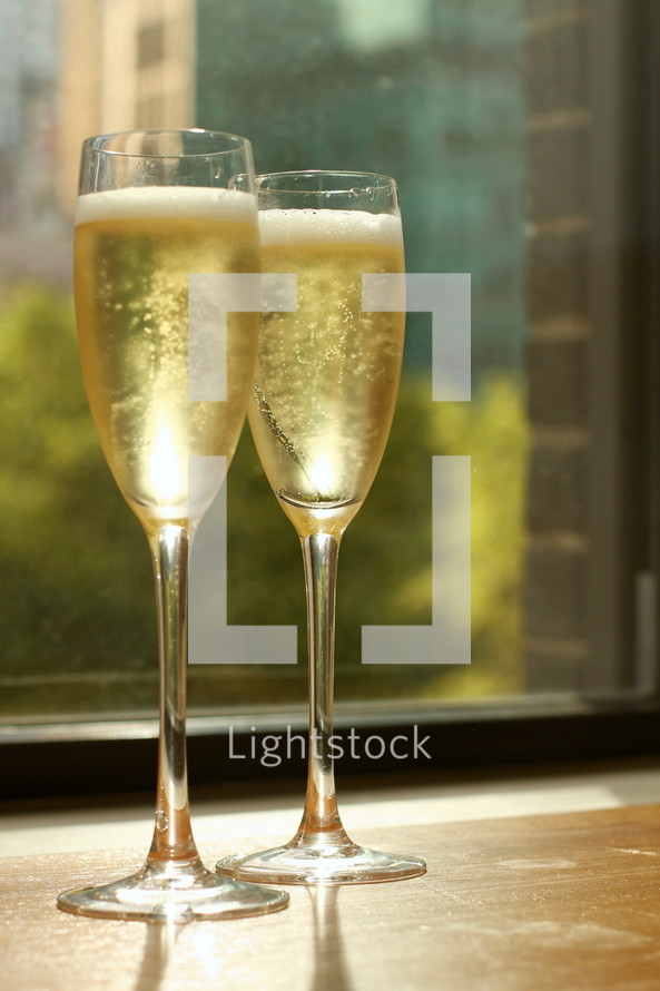 champagne glasses in a window sill 