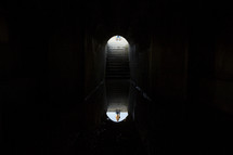 reflection of light in water and a man at the entrance of a cellar 