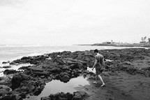 man walking on a rocky beach 