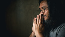 Man praying with hands folded