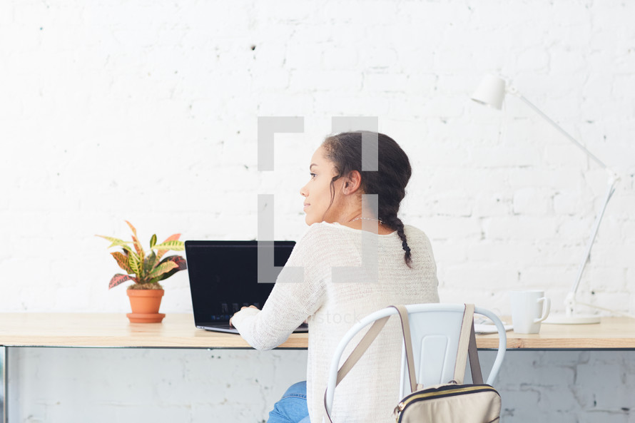 woman sitting at a desk with a laptop computer 