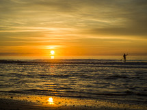 paddle boarder at sunset 