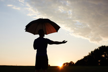 silhouette of a man holding an umbrella 