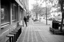 a man leaning against a wall on a downtown sidewalk 