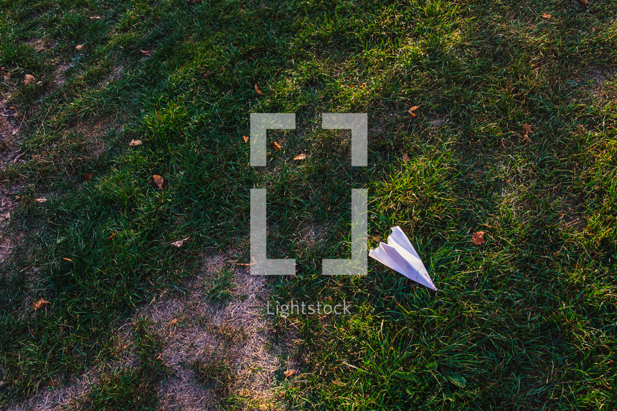 paper airplane on a lawn 