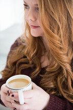 woman in thought holding a cup of coffee 