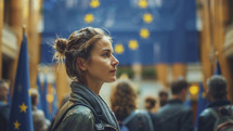 Thoughtful young woman in a European Union setting, gazing forward amidst EU flags, embodying hope and engagement in political processes.