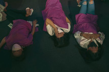women lying on the floor during a worship service 