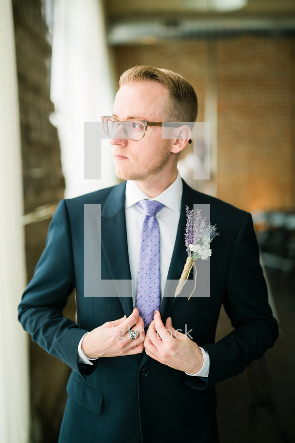 a man in a suit and tie with boutonniere