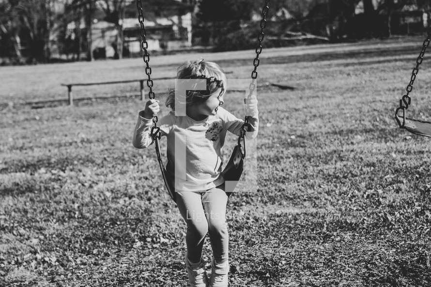 child on a swingset 