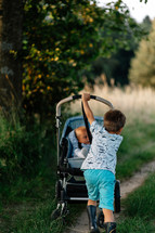 Brother and sister go for a walk with buggy