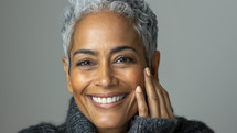 Joyful mature woman with silver hair and a beaming smile.