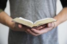 A man holding an open book in his hands.