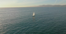 Flying around sailboat in the ocean. Sailboat on ocean bay aerial. Summer sea cruise on ship. 