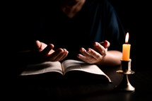 Bible and candlelight with praying woman