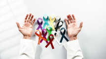 world cancer awareness day and ribbons in the hand of a doctor