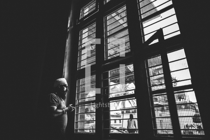 man looking out a window 