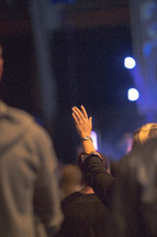audience at a concert with raised hands 