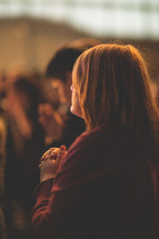 a woman in prayer at a worship service 