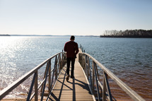 man walking down a dock 