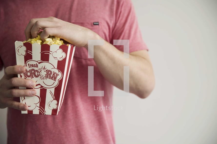 man holding popcorn 
