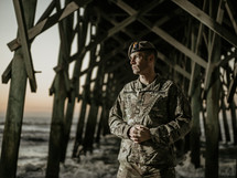 portrait of a soldier under a pier at a beach 