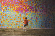 man looking at abstract art on a wall 