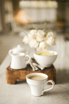 coffee cups, creamer, sugar, table 