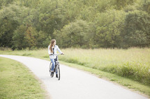 a teen girl riding a bicycle 