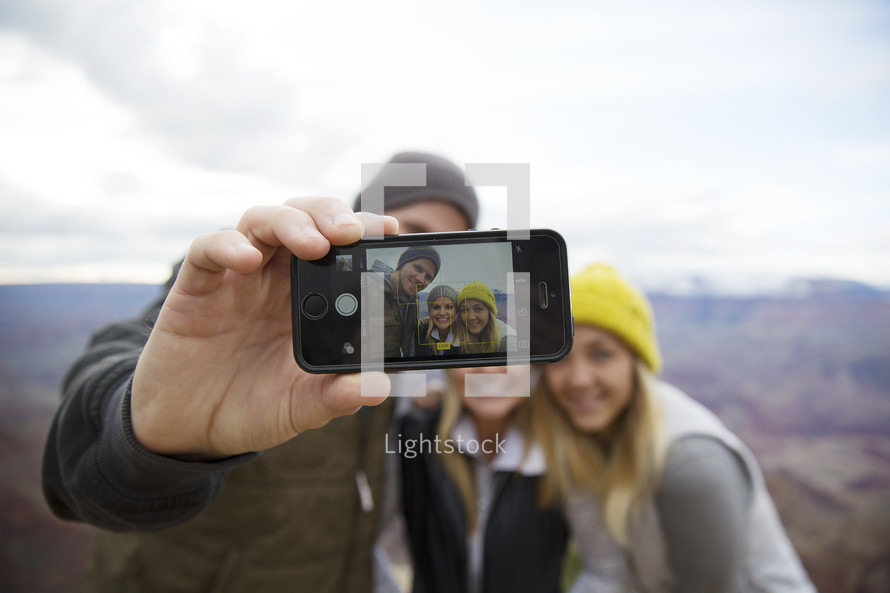 friends taking a selfie on a mountaintop 