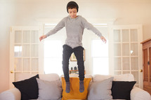 boy jumping on a couch 
