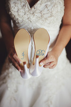 a torso holding her shoes that say I do 