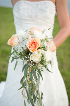 torso of a bride holding a bridal bouquet 