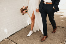 bride and groom walking holding hands 